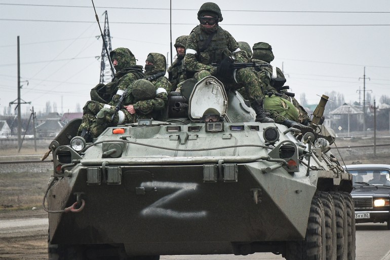 Russian soldiers on an armoured vehicle move towards mainland Ukraine on a road near Armiansk, Crimea, on Friday [EPA-EFE]