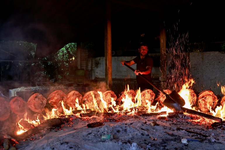 A man prepares Masgouf, a traditional fish, on a wood-fired in Abu Nawas in Baghdad