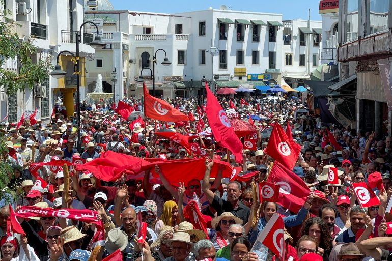FILE PHOTO: Demonstrators hold flags as they gather during a protest in opposition to a referendum on a new constitution called by President Kais Saied, in Tunis, Tunisia June 18, 2022. REUTERS/Jihed Abidellaoui/File Photo
