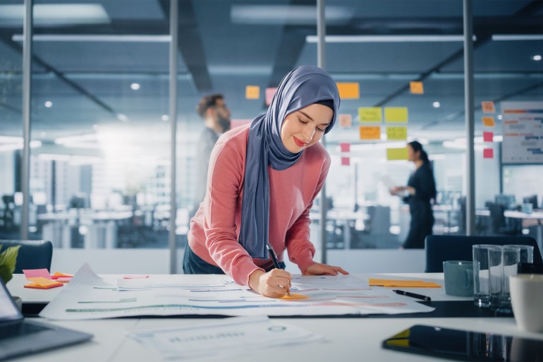 SS2101929391 Modern Office: Portrait of Muslim Businesswoman Wearing Hijab Works on Engineering Project, Does Document and Blueprints Analysis. Empowered Digital Entrepreneur Works on e-Commerce Startup Project