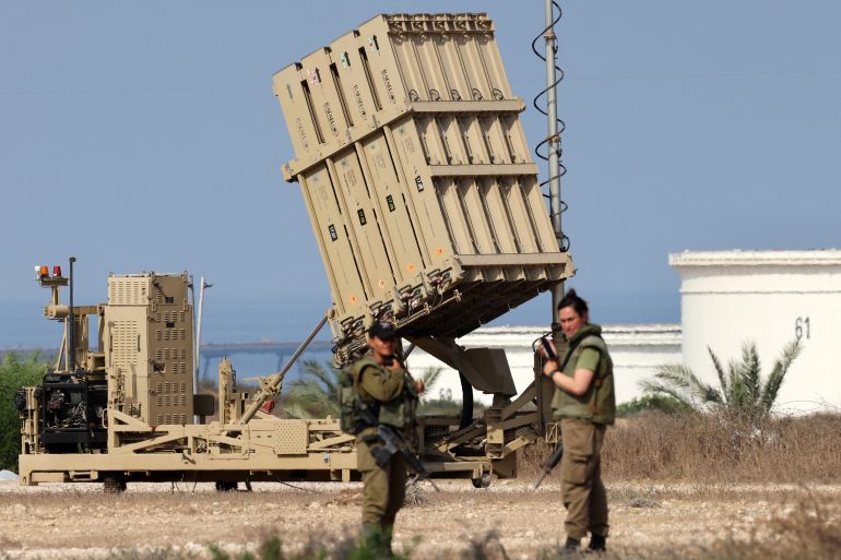 Israeli soldiers stand near a battery of Israel's Iron Dome defence missile system, designed to intercept and destroy incoming short-range rockets and artillery shells, deployed in Ashkelon in southern Israel on August 6, 2022. - Israel on August 6 hit Gaza with air strikes and the Palestinian Islamic Jihad militant group retaliated with a barrage of rocket fire, in the territory's worst escalation of violence since a war last year. Israel has said it was forced to launch a "pre-emptive" operation against Islamic Jihad, insisting the group was planning an imminent attack following days of tensions along the Gaza border. (Photo by Jack Guez / AFP)