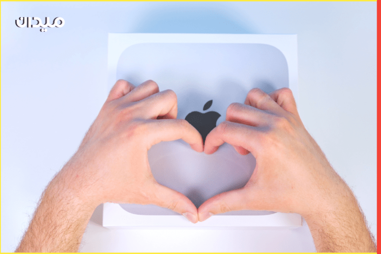Caucasian man making heart shape with hands. Love for Apple brand. A man makes a heart shape against background of a box of a new apple mac mini with m1 chip. Russia, Orel, 02.28.2022