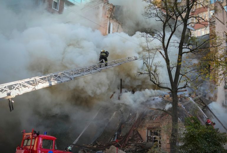 Firefighters working at a building damaged by a drone attack, [Efrem Lukatsky/AP Photo