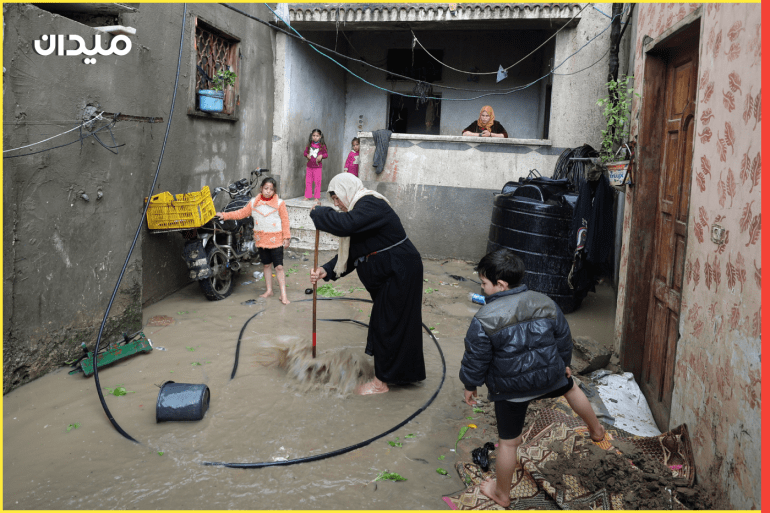 A Palestinian woman tries to remove water at her flooded house following heavy rains in the northern Gaza Strip November 26, 2020. REUTERS/Mohammed Salem