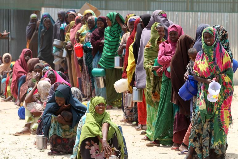 Internally displaced Somali women stand in a queue waiting for relief food to be served in Hodan district south of capital Mogadishu