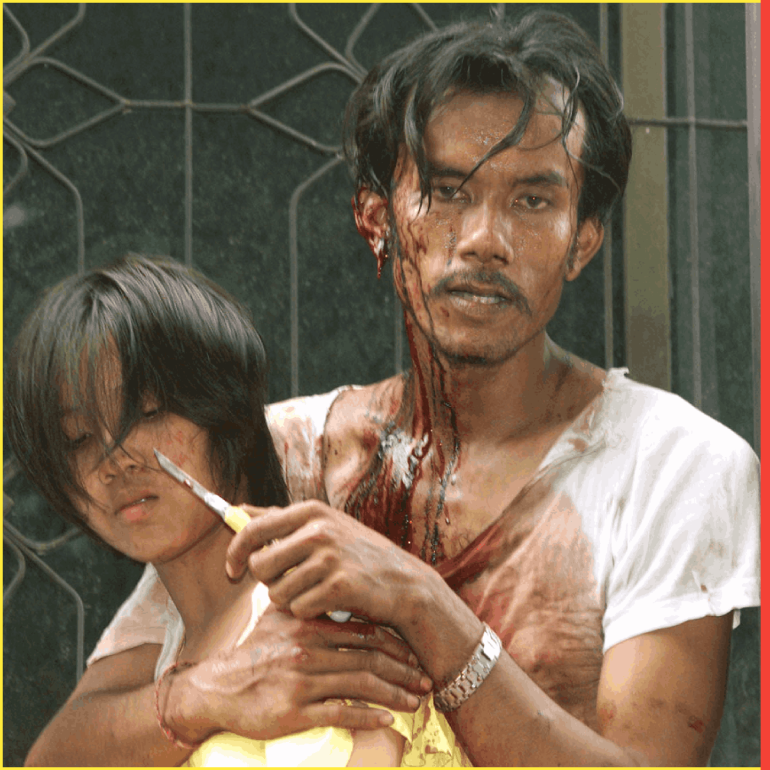 A Thai man known only as "Tee", high on metamphetamine drugs and covered in his own blood after cutting himself in a rage, takes 19-year-old university student Patcharapan Tiyawanich hostage in a siege which lasted over three hours before police overpowered him and freed the girl in central Bangkok August 29, 2002. Thai authorities estimate that around 700 million methamphetamine pills flood Thailand annually, a cheap but strong drug widely used among labourers and truck drivers to help work long hours but whose side effects include paranoia and violent bahaviour. REUTERS/Sukree Sukplang JIR/PB