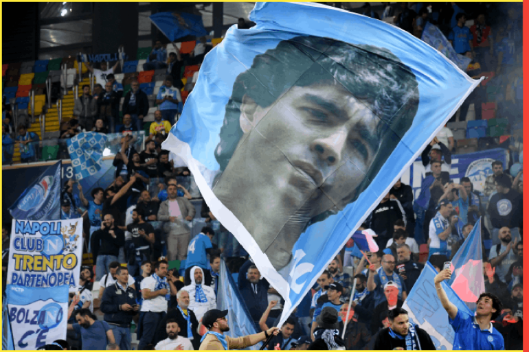 UDINE, ITALY - MAY 04: SSC Napoli fans wave a Diego Maradona flag after their side wins the Seria A title after the Serie A match between Udinese Calcio and SSC Napoli at Dacia Arena on May 04, 2023 in Udine, Italy. (Photo by Alessandro Sabattini/Getty Images)