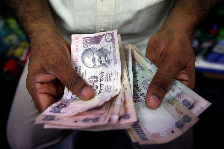 FILE PHOTO: A private money trader counts Indian Rupee currency notes at a shop in Mumbai August 1, 2013. REUTERS/Vivek Prakash/File Photo