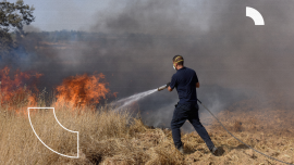 An Israeli firefighter attempts to extinguish a fire near Kibbutz Kfar Azza, along the border of the Gaza Strip, that was ignited by kites sent by Palestinian protesters in Gaza, June 5, 2018. Over 600 kites have been flown into Israel from the Gaza Strip, destroying 9000 square meters of crops and forests.