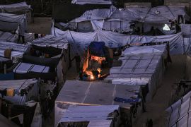 The tent camps of displaced Palestinians are pictured in Rafah in the southern Gaza Strip close to the border with Egypt after sunset on December 31, 2023 amid the ongoing conflict between Israel and the militant group Hamas. (Photo by AFP)