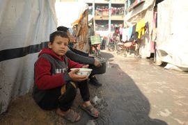 أطفال ينتظرون للحصول على كميات من الطعام في مدينة جباليا شمال قطاع غزة (الأناضول)