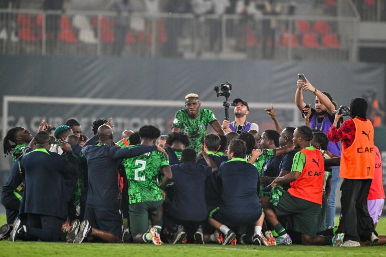 Nigeria's forward #9 Victor Osimhen (C) and teammates celebrate the victory at the end of the Africa Cup of Nations (CAN) 2024 semi-final football match between Nigeria and South Africa at the Stade de la Paix in Bouake on February 7, 2024. (Photo by Issouf SANOGO / AFP)