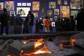 People visit the 'This Is Not An Exhibition' section displaying paintings by Gazan artists, as the Palestinian Museum reopened in the town of Birzeit in the occupied West Bank on February 11, 2024. - The museum reopened following closure in the aftermath of the October 7 attacks and ensuing conflict with Israel, with several exhibits showcasing Gazan art and heritage from collections and individuals in the West Bank. (Photo by Zain JAAFAR / AFP)