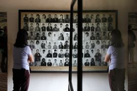 A tourist looks at photographs of Khmer Rouge victims at the Tuol Sleng Genocide Museum, also known as the notorious security prison S-21, in Phnom Penh January 21, 2015. The U.N backed tribunal in Cambodia on Wednesday commenced the second phase of a hearing of two former top Khmer Rouge leaders, head of state Khieu Samphan and ''Brother Number Two'' Nuon Chea, on charges of genocide against the ethnic Chams and the Vietnamese. REUTERS/Samrang Pring (CAMBODIA - Tags: CRIME LAW TRAVEL POLITICS CIVIL UNREST)