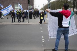 متظاهر فلسطيني في ألمانيا يواجه مجموعة من مؤيدي إسرائيل على هامش مسيرة تطالب بوقف النار في غزة (وكالة الأناضول)