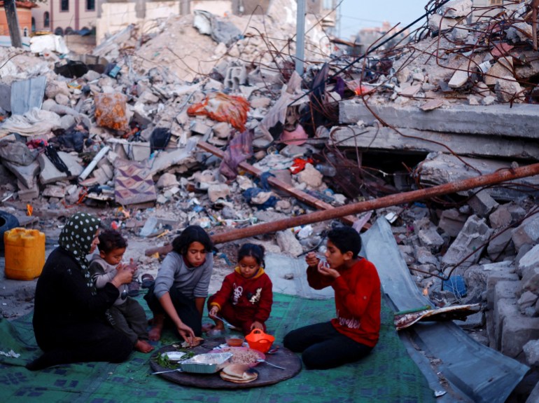 Palestinians break their fast amid the rubble of their destroyed home during the Muslim holy fasting month of Ramadan, as the conflict between Israel and Hamas continues, in Rafah, in the southern Gaza Strip March 13, 2024. REUTERS/Mohammed Salem REFILE - QUALITY REPEAT