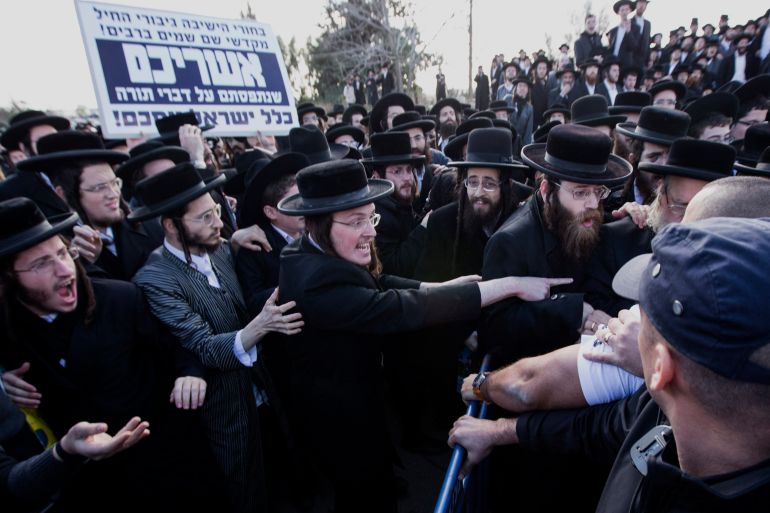 Ultra-Orthodox Jewish men rally following the arrest of a young man who refused to serve in the Israeli the army, as they protest outside the Atlit military prison near the northenr coastal city of Haifa, on December 9, 2013. The Ultra-Orthodox community places great value on religious scholarship and believe that Torah study plays a role in protecting the Jewish people. Following Israel's establishment in 1948, they were allowed to forego military service in favor of religious studies. Today their are some 3000 Ultra-Orthodox men serving in the Netzach Yehuda, an all-Haredi (Ultra-Orthodox community known as Haredim) battalion, some of whom are going against the wishes of many in their community. AFP PHOTO / JACK GUEZ (Photo by JACK GUEZ / AFP)