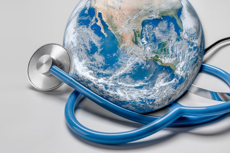 Global human health in context of coronavirus pandemic. Stethoscope wrapped around globe Earth on white background. Global health,Green Earth day concept. Elements of this image were furnished by NASA