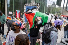 مناصرون للقضية الفلسطينية يرتدون الكمامات خلال مشاركتهم في مظاهرة بنيويورك (رويترز)