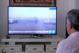 مواطن إيراني يتابع التقارير الإخبارية عن حادث مروحية الرئيس (الأناضول)