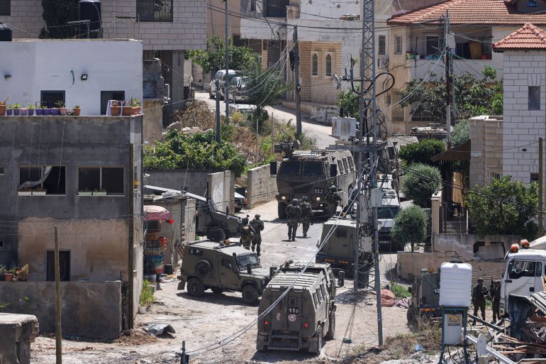 Israeli army vehicles block a road during a raid in the occupied West Bank town of Deir al-Ghusun near Tulkarem on May 4, 2024. (Photo by JAAFAR ASHTIYEH / AFP)