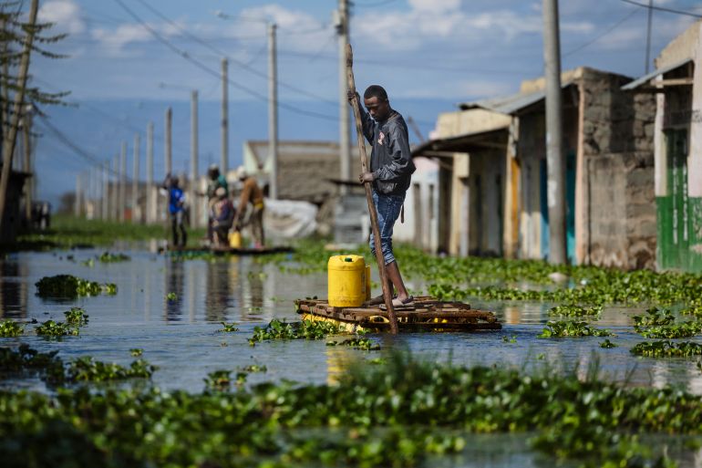 Residents use push poles to manuever their makeshift rafts over a flooded access road to their residential blocks at Kohoto estate in Naivasha on November 17, 2025.