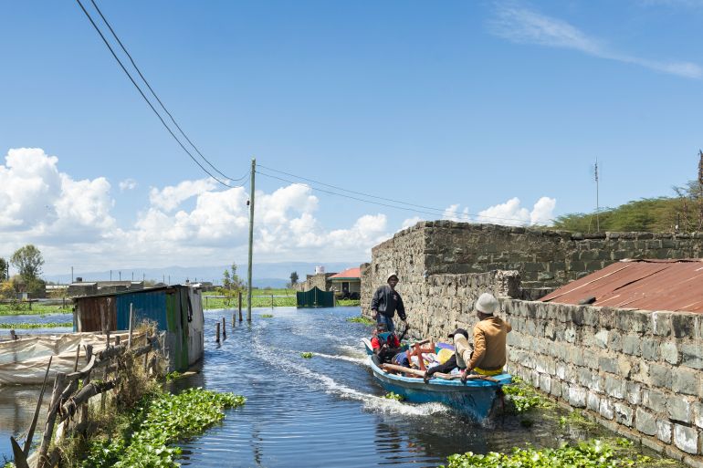 Boat operators ferry a man and his household belongings after he was forced to evacuate his flooded residence at Kihoto estate in Naivasha on November 17, 2025.
